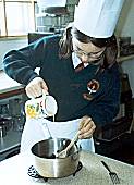 Siobhra Aikin Adding the beaten egg to the mixture in the saucepan